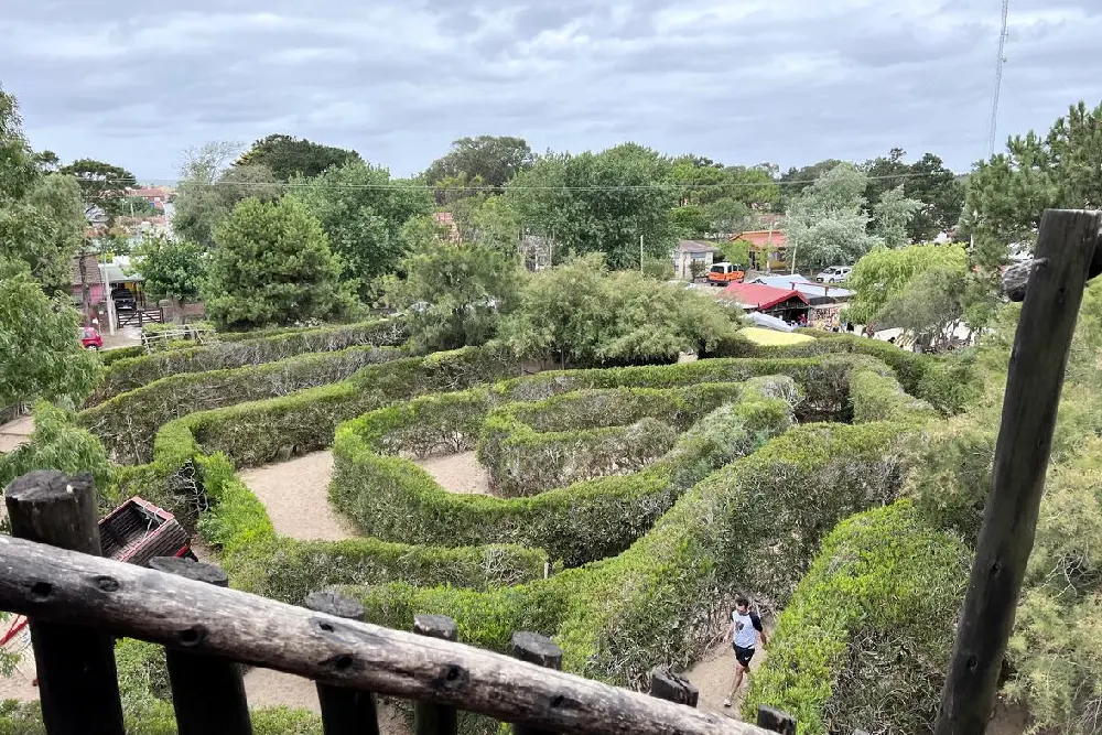 El laberinto visto desde la baranda de madera del mirador, con una persona corriendo por uno de los pasillos