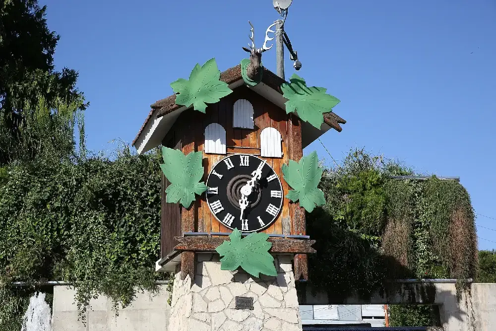 El Reloj Cucú de Villa Carlos Paz, una gran casita de madera con números romanos, hojas verdes y una cabeza de ciervo
