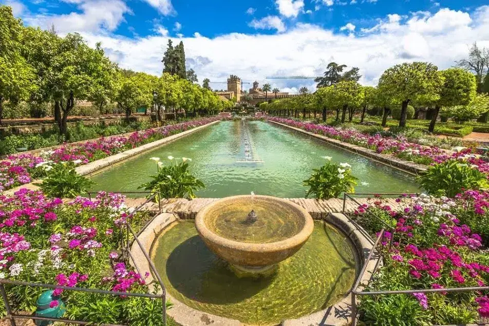 Fuente de agua rodeada de flores en el Jardín Botánico de Córdoba
