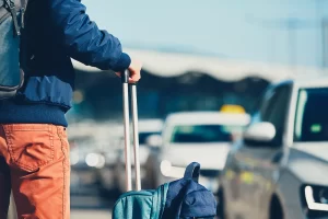 Una persona sosteniendo una valija, a punto de viajar.