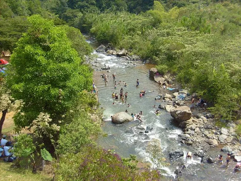 Personas bañándose en el arroyo durante el verano