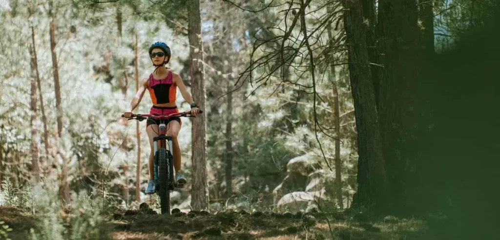 Mujer andando en bici por el bosque