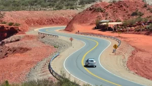 Vista panorámica de una carretera con auto andando y montañas alrededor