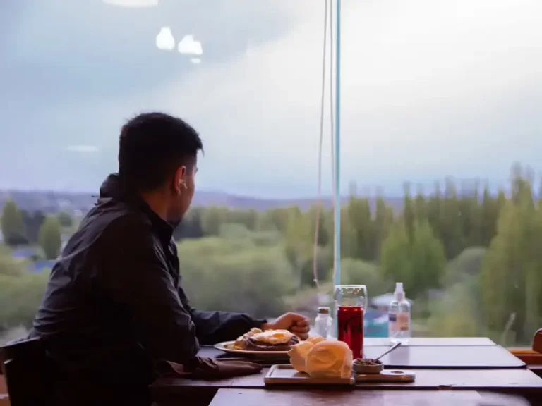Hombre mirando a la ventana mientras disfruta de una comida