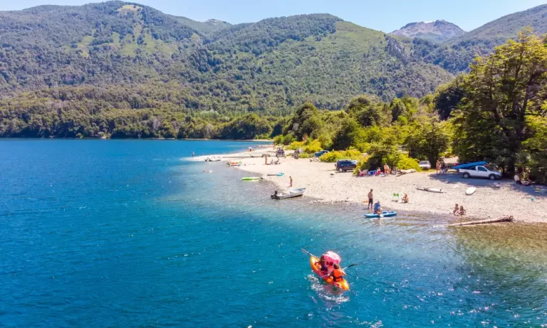 Turistas disfrutando del agua y arena en Lago Mascardi