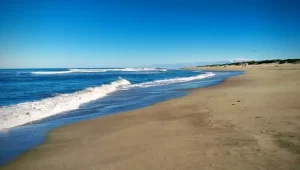 Playa con arena lisa y mar con olas